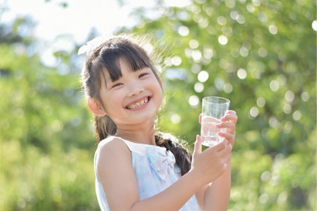 笑顔で水を飲む女の子