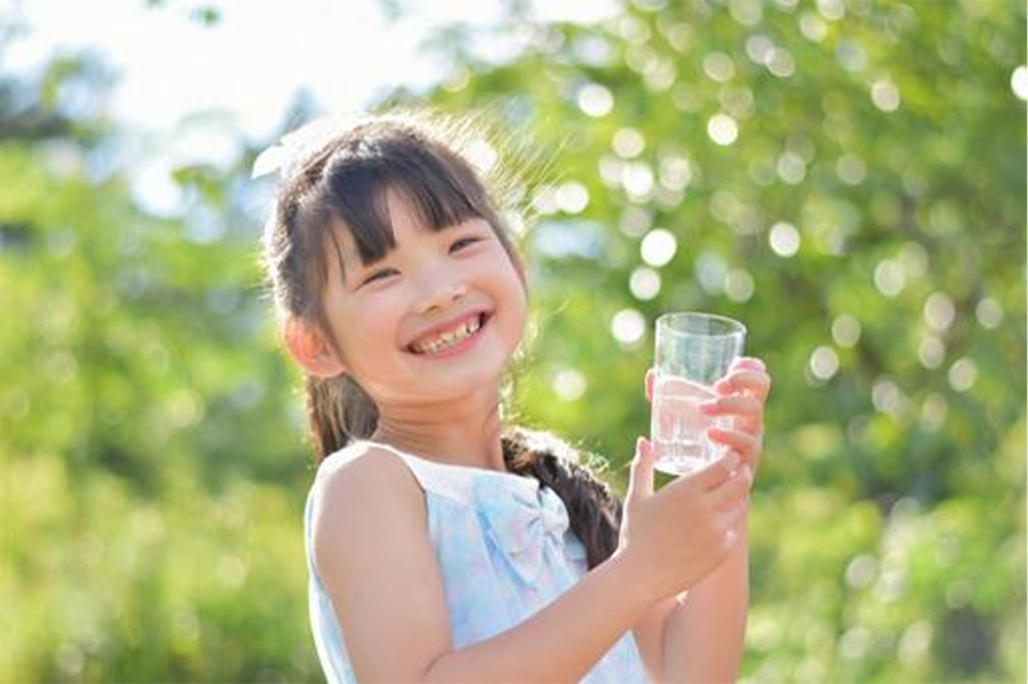 笑顔で水を持つ子ども